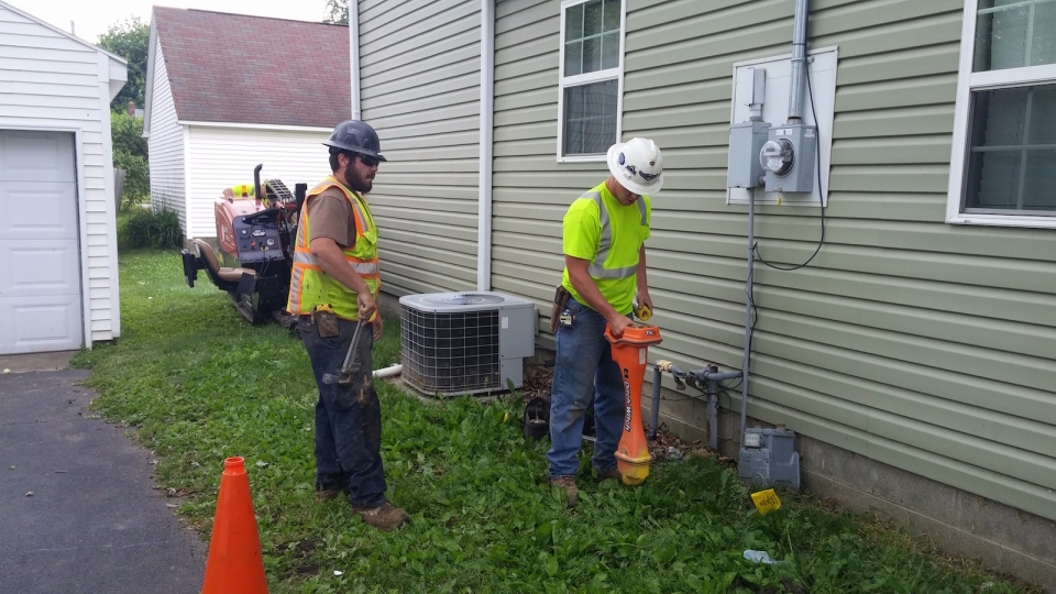 Same two Workers outside of a house.